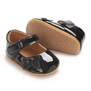 Close-up view of black patent leather baby princess shoes with butterfly detail