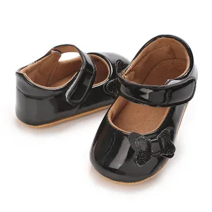 Close-up detail of black patent leather baby princess shoes with a sparkly bow accent