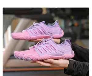 Dettaglio di scarpe a piedi nudi rosa per outdoor con lacci a strozzo regolabili.
