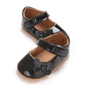 Detailed view of black patent leather baby girl princess shoes with glittery bow