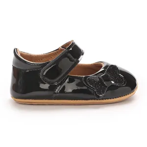 Detailed side view of black patent leather baby girl princess shoes with a glittery bow