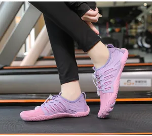Primo piano di scarpe da acqua minimaliste viola su un tapis roulant da palestra