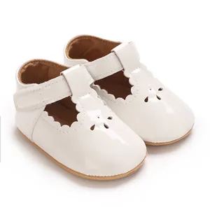 Macro detail of white scalloped baby princess shoes featuring anti-slip rubber soles