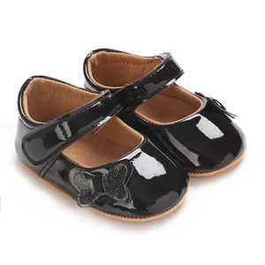 Close-up of black patent leather baby girl princess shoes with butterfly bow detail
