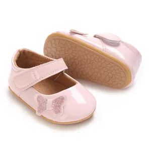 Close-up view of pink baby girl princess shoes featuring a sparkly glitter butterfly detail