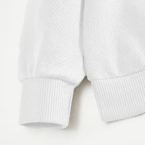 Primer plano de la textura del tejido jacquard blanco y puños acanalados en sudadera polo