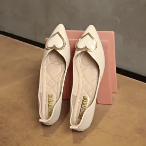 Elegant cream beige pointed-toe flat shoes featuring a stylish gold heart-shaped buckle design