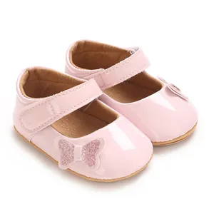 Detailed shot of pink glossy baby girl princess shoes with glitter butterfly ornament