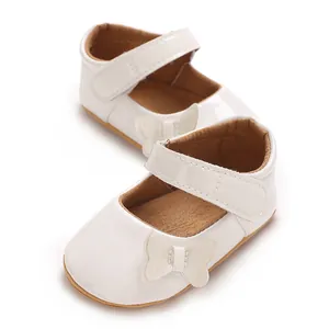 Detail of white patent leather baby girl princess shoes with butterfly bow and strap