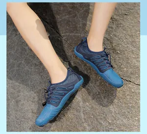 Outdoor blue barefoot water shoes for hiking and surfing shown on a rocky ground surface
