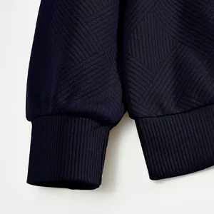 Detalle del tejido jacquard pesado azul marino y los puños acanalados de la sudadera