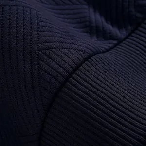 Vista detallada del tejido jacquard azul marino pesado con elegantes motivos de canalé.