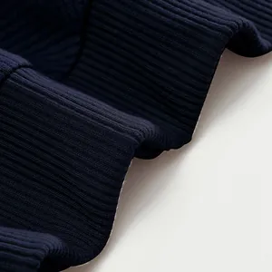 Primer plano de la textura de punto acanalado azul marino pesado de una sudadera polo.
