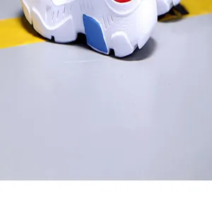 Detailaufnahme der weichen Sohle weißer Jungen-Laufschuhe mit blauen Farbakzenten.
