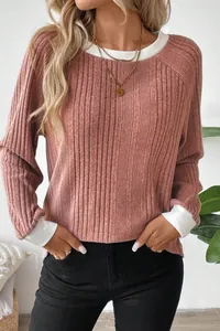 Close-up of elegant pink ribbed knit long sleeve sweater with white contrast trim
