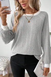 Close-up of grey ribbed long sleeve sweater with white color block collar and cuffs