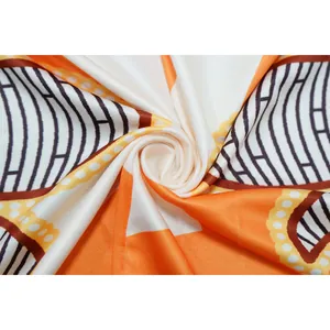 Detalle macro de la tela suave del vestido estampado con motivos geométricos naranjas