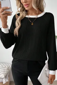 Close-up detail of black ribbed sweater with white contrast collar and cuffs for women