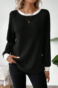 Detailed view of women's black ribbed knit sweater with contrasting white crew neck and cuffs.