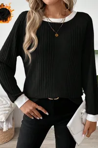 Detail view of black ribbed knit sweater with white trim collar and cuffs