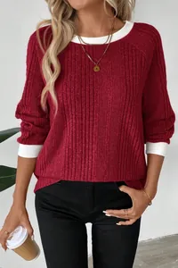 Detail of a red ribbed long-sleeve sweater with white contrasting neck and cuffs