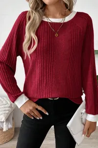 Close-up of burgundy ribbed knit sweater with white contrast collar and cuffs.