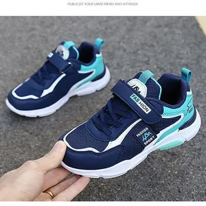 Close-up of navy blue boy's running shoes with teal accents and velcro strap