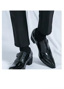 Primo piano di scarpe monk da uomo in pelle verniciata nera con tacco grosso