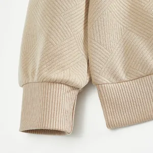 Primer plano de la tela de jacquard pesado y puño acanalado en sudadera color beige