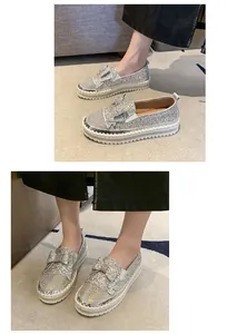 Gros plan sur les mocassins à plateforme argentés avec nœud en strass