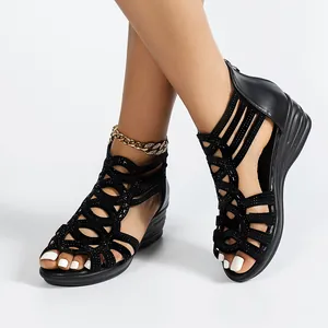 Close-up of black Roman wedge sandals with sparkly details and soft sole