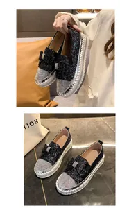 Détail de mocassins noirs à paillettes avec nœuds et bouts en strass étincelants.