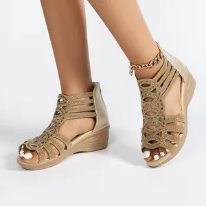 Detail view of gold Roman wedge sandals with rhinestone hollow design on a model.