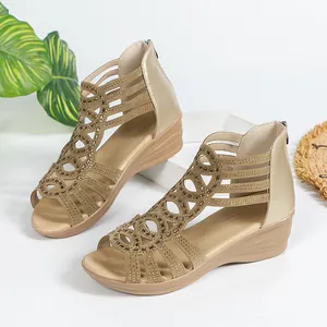 Detailed view of gold Roman wedge sandals with sparkling rhinestones and cut-out patterns