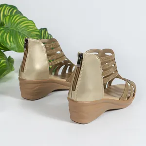 Detail of women's gold wedge sandals featuring a rear zipper and rhinestone straps.