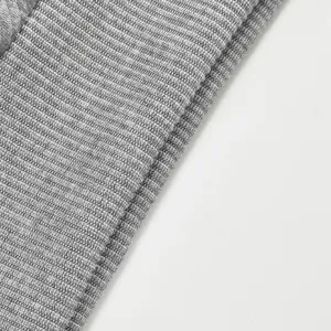Primer plano macro de la textura de punto acanalado gris en una sudadera de jacquard pesado.