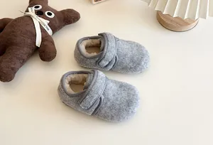 Nahaufnahme grauer Plüsch-Hausschuhe für Kinder mit warmem Fleecefutter.