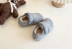 Nahaufnahme von warmen grauen Kinder-Plüschloafers mit weichem Kunstfellfutter