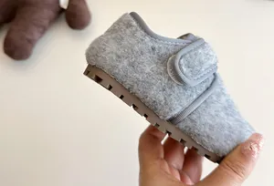 Detailansicht der Textur von grauen, flauschigen Kinderwinterschuhen mit weicher Gummisohle