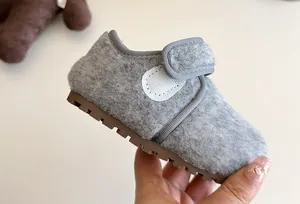 Nahaufnahme von grauen Kinder-Winter-Pelzschuhen mit weicher rutschfester Gummisohle