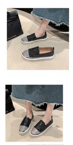 Dettaglio delle scarpe slip-on nere glitterate con punta in strass colorati e plateau.