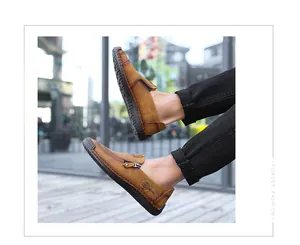 Detailed view of men's casual brown leather loafers with side zipper and tree logo.
