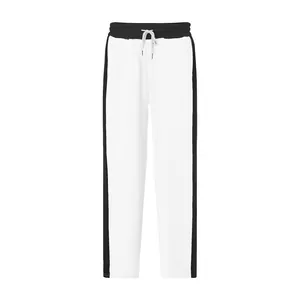 Close-up of white straight-leg sweatpants with black side stripes and drawstring.