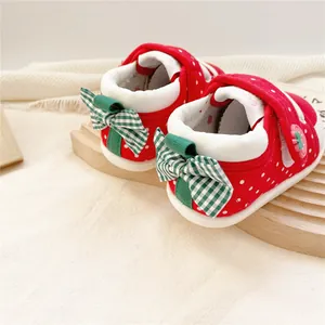 Gros plan détaillé de chaussures de marche bébé fraise avec nœuds à carreaux verts