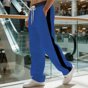 Detail view of blue heavyweight men's sweatpants with black side stripes and drawstring.