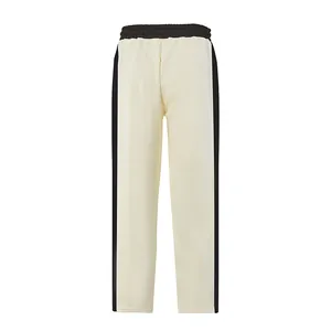 Detalle de pantalón casual crema para hombre con rayas laterales negras y cordón