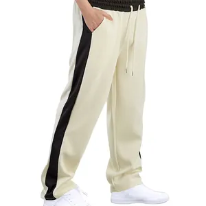 Detalle de pantalones rectos sueltos para hombre con franja de contraste y cordón.