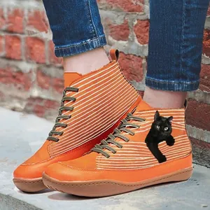 Close-up of vintage orange high-top boots featuring a black cat print and lace-up design.