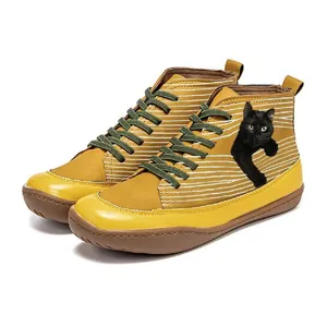 Close-up of yellow high-top Martin boots with realistic black cat print and stripes