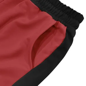 Close-up of side pocket and waistband on men's red and black sports sweatpants